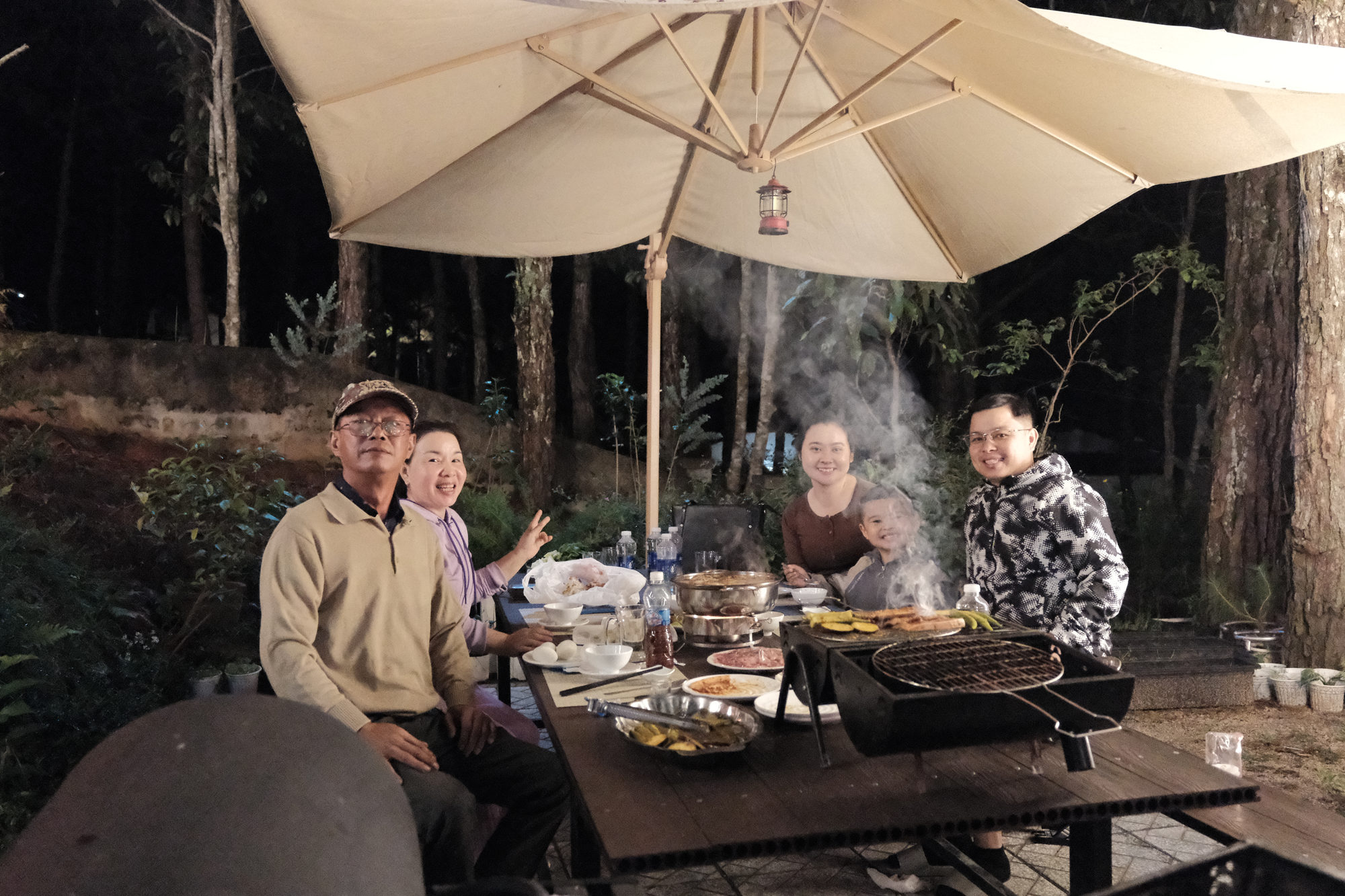 Gia đình cười vui bên bàn tiệc BBQ dưới dù tại GIA AN