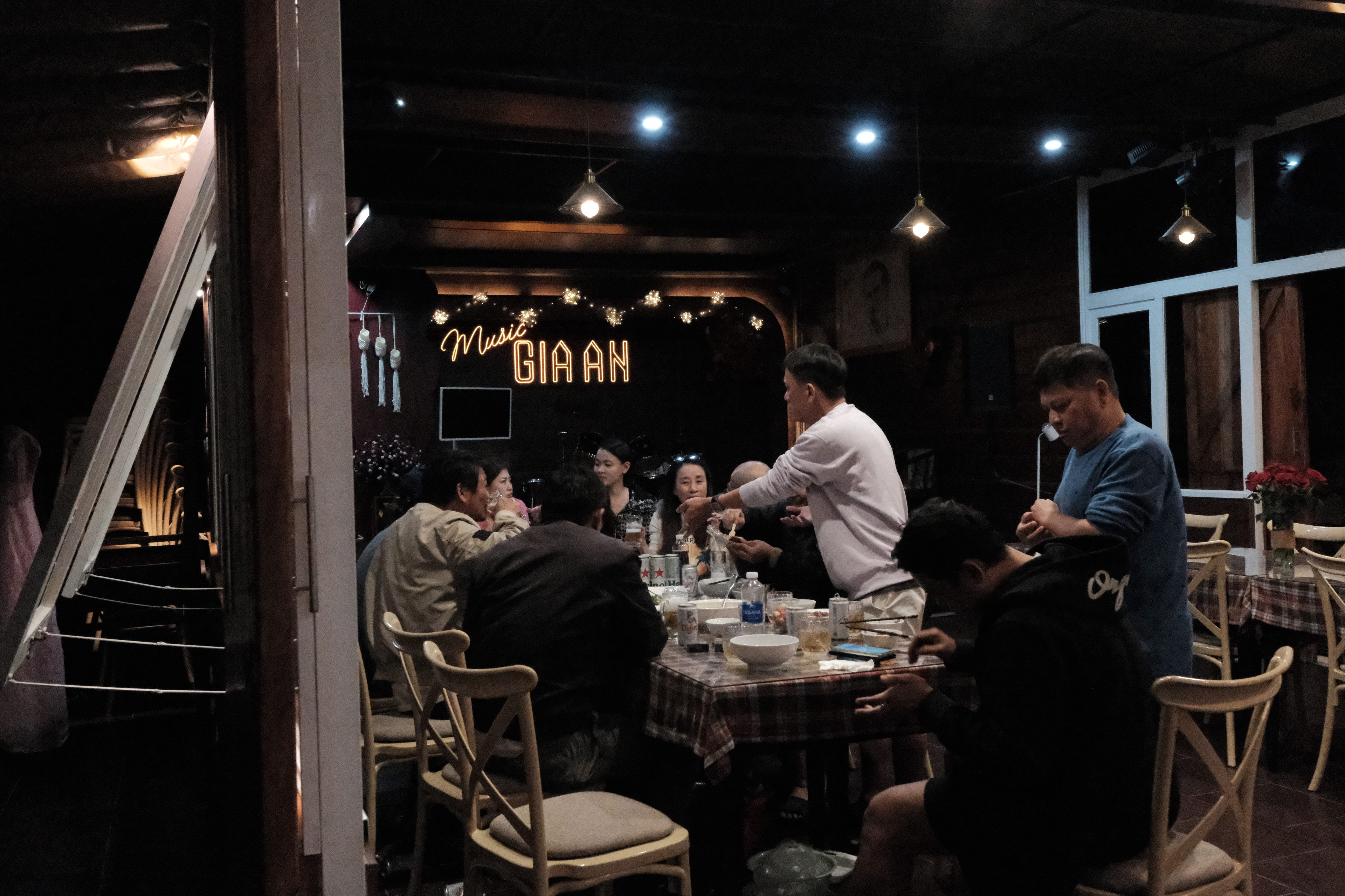 Tiệc BBQ buổi tối của đoàn dưới tán thông, bàn dài, đèn lồng và bếp nướng tại GIA AN Hotel Dalat