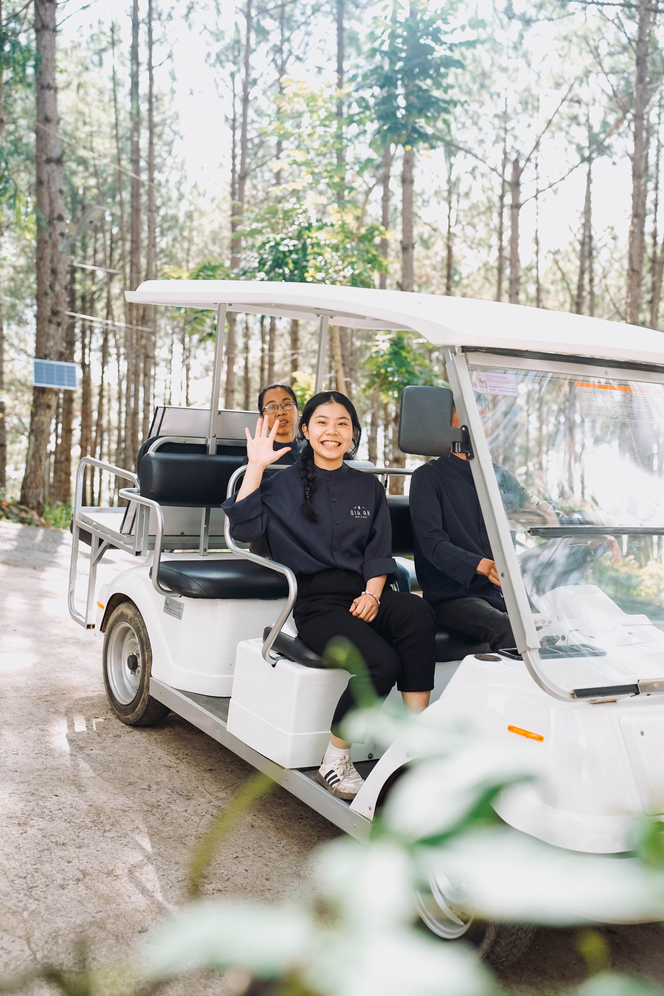 Nhân viên GIA AN vẫy tay trên xe buggy giữa rừng thông